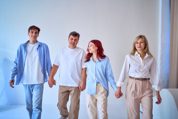 a family, middle-aged husband and wife, young adult son and teenage daughter, on a white background, studio photo shoot