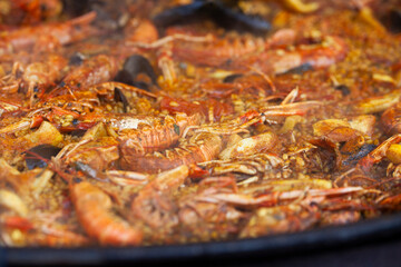 .Authentic seafood paella, made with fresh shrimp, mussels, squid, and tender fish, all simmered with saffron, garlic, bell peppers, tomatoes, and a touch of paprika.