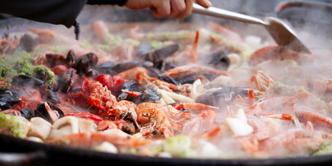 .Authentic seafood paella, made with fresh shrimp, mussels, squid, and tender fish, all simmered with saffron, garlic, bell peppers, tomatoes, and a touch of paprika.