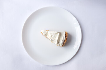A piece of banoffee banana pie with caramel sauce and cheese cream on the white background. Traditional english cake. Ready to eat. Cooking concept