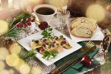 A plate with smoked herring fillets in oil with cranberries on Christmas table