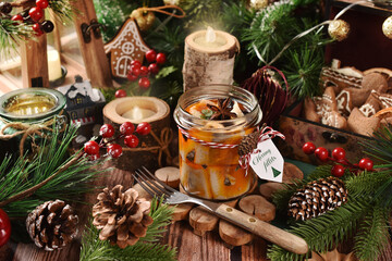 A jar of herring fillets in oil with prunes on Christmas table