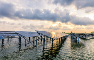 Solar panels on river and cloudscape at sunset