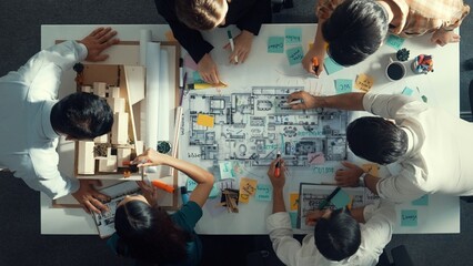 Top aerial view of project manager or civil engineer writing at blueprint and planning building...