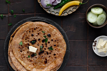 Indian Paratha with melted butter and vegetables. Healthy Indian bread or pita. Indian cuisine. Top view