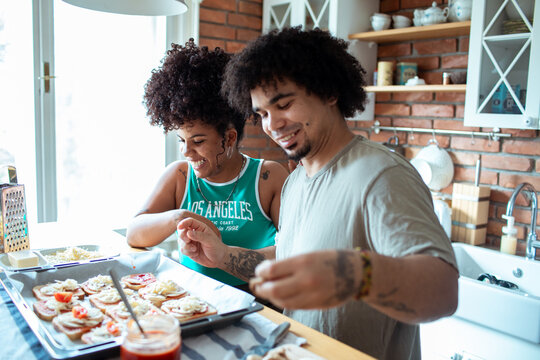 Friends cooking homemade pizza together in the kitchen