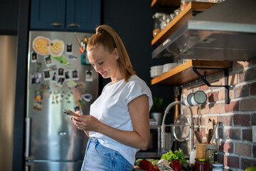 Young woman cooking healthy vegetables in modern kitchen