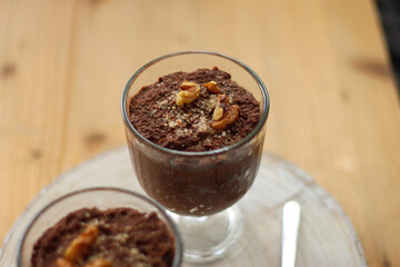 Two bowls of chia seed, chocolate and orange pudding. Healthy snack, wooden background. Selective focus.