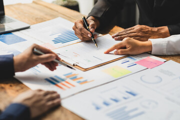 Businessman meeting with financial advisors discussing budget analysis, financial statistics figures and finance planning on wooden tables in the office.