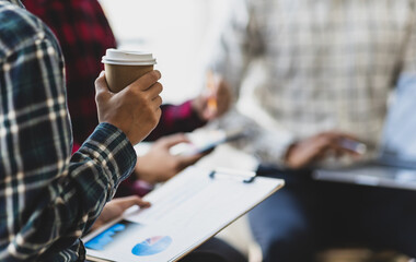 Coworkers sitting in a meeting talking to discuss work in the office.