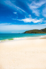 beach with a rocky shoreline and a small hut in the distance