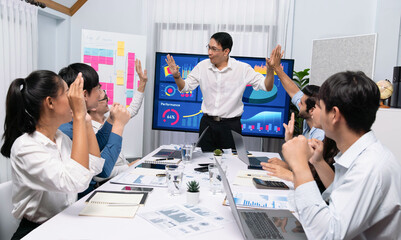 Fototapeta premium Analyst team leader celebrate and high five together with his colleague after successful data analysis meeting using FIntech software power with business intelligence or BI dashboard. Prudent