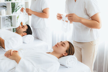 Obraz premium Serene modern daylight ambiance of spa salon, couple customer indulges in rejuvenating with facial skincare mask. Facial skin treatment and beauty cosmetology procedure for face. Quiescent