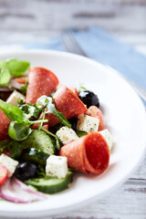 Salad with Salami, Feta Cheese, Black Olives, Cucumber and Cherry Tomatoes. Close up.