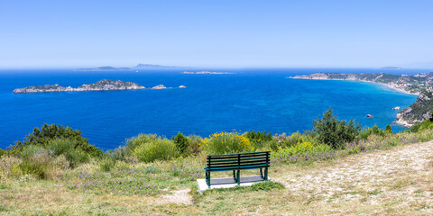 View from a bench on Arillas Bay with turquoise sea panorama on Corfu island in Greece