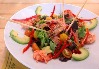 a plate of food with shrimp, salad and avocado.