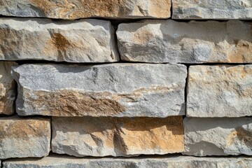 A close-up view of a stone wall featuring various textured stones in natural colors.