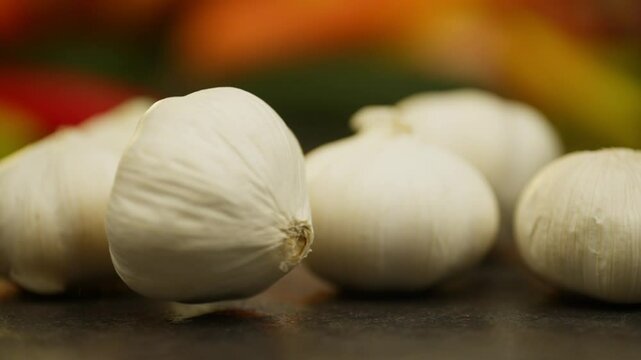 A slow-motion video in which a head of garlic flies into the frame, knocking out all the others. High quality FullHD footage