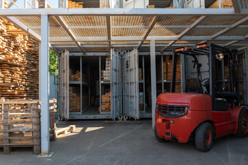 Warehouse forklift and stacked lumber in storage