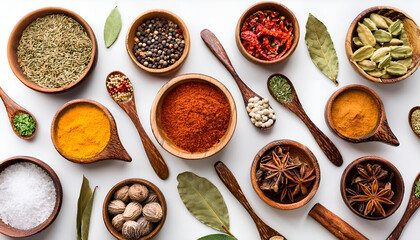 Top view of a diverse assortment of colorful spices arranged in wooden bowls and spoons on a white surface, showcasing the rich textures and vibrant hues of culinary ingredients.