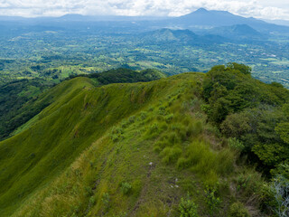 Cima del cerro con césped verde y nubes de fondo