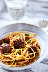 Spaghetti Pasta with Meatballs and fresh Basil on bright background. Close up.