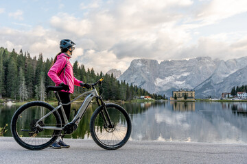 Obraz premium Cycling Adventure: Woman Enjoying the Views at Lake Misurina