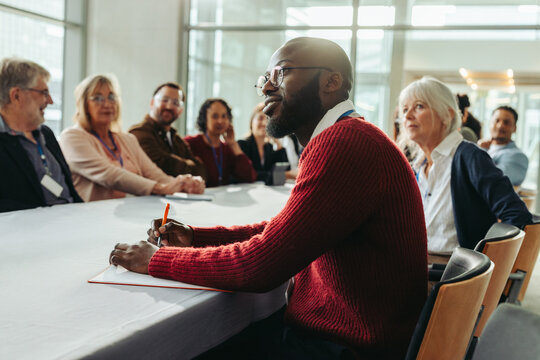 Confident businessman listening attentively in a meeting with colleagues - Powered by Adobe