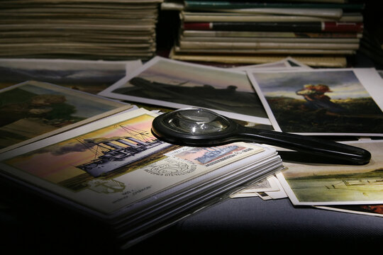 Still life with a magnifying glass and a collection of postcards with images of works of art