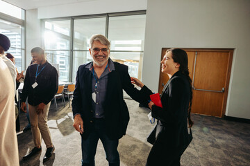 Joyful interaction among multi-generational colleagues in a conference setting, showcasing diverse age range and teamwork