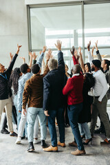Obraz premium Diverse group celebrates success with teamwork and togetherness in a modern office setting