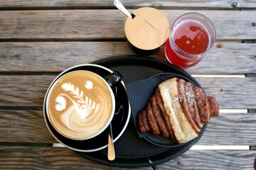 Franzbrötchen (Blätterteig mit Zimt), Cappuccino, Rhabarberlimonade und Zuckerdose im Hintergrund.