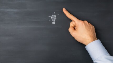 A hand points to a light bulb sketch on a chalkboard, symbolizing ideas, creativity, and inspiration. Blank chalkboard