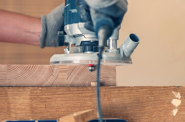 Close-up of a hand router smoothing wooden board edges, precision woodworking in action