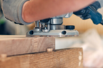 Hand router in action, finishing wooden board edges with expert craftsmanship