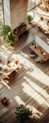 Overhead view of a modern office with wooden floors and natural light streaming in.