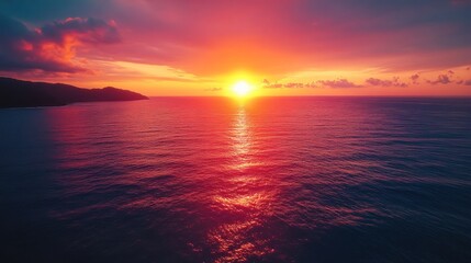 Obraz premium A vibrant sunset over the ocean, with a fiery sky and a glowing sun reflecting on the water.