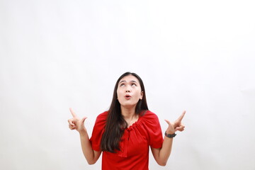 Young hispanic woman wearing casual red shirt amazed and surprised looking up and pointing with fingers and raised arms.