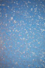 Close-Up of Frost Crystals on Glass Against a Clear Blue Sky Background