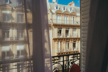 Elegant view of a Parisian building facade with ornate balconies and classic windows, framed by...