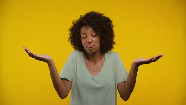 Woman Shrugging in Front of Yellow Background