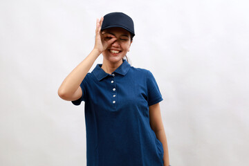Young hispanic woman courier wearing delivery uniform and cap doing ok gesture with hand smiling, eye looking through fingers with happy face.