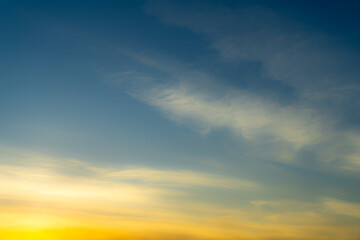 Blue and Golden Sky with Colorful Light Pink Cirrus Clouds at Sunset. Wallpaper Texture Background.