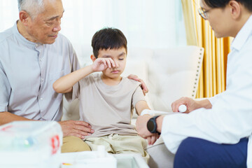 Obraz premium The boy got an accident on his arm then grandfather is taking him to see a doctor.