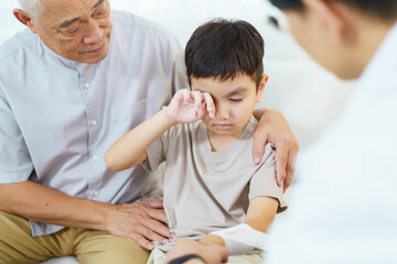 Fototapeta premium The boy got an accident on his arm then grandfather is taking him to see a doctor.