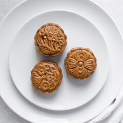 Overhead view of homemade mooncakes, top view of baked mooncakes on white plate, process of making mooncakes for Lunar New Year and mid autumn festival