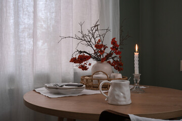 A Cozy Table Setting That Incorporates Beautiful Autumn Decor and Warm Candlelight Shadows