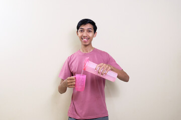 Young Asian man pouring a glass of water