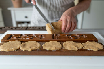 Woman preparing and baking christmas cookies, german spekulatius in the kitchen
