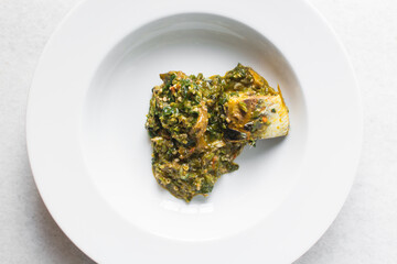 Overhead view of Nigerian okro vegetable soup in a white plate, top view of okro soup in a soup plate